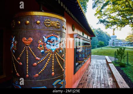 Schrein mit mehreren Gebetsrädern und Chorten-Struktur im Hintergrund Stockfoto