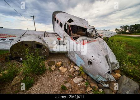Altes verlassenes abgestürztes Flugzeug auf Feldern an bewölkten Tagen Stockfoto