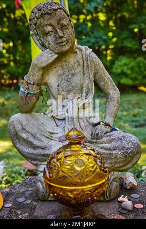 Details der tibetischen mongolischen buddhistischen Statue aus Stein, umgeben von natürlichen Spenden Stockfoto