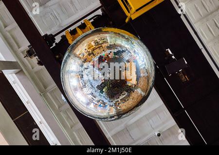 Reflektierende große Discokugel an der Decke des alten Gebäudes Stockfoto
