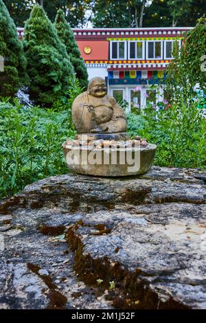 Kleine tibetische mongolische buddhistische Statue auf Felsen im Garten beim Kulturzentrum Stockfoto