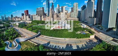 Blick über den Millennium Park mit Wanderbrücke und Theater im Zentrum von Chicago, gesäumt von Wolkenkratzern Stockfoto