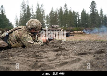 Ein Green Beret mit 1. Special Forces Group (Airborne) greift Langstreckenziele während des Menton 2022 Best Sniper Competition auf der Joint Base Lewis-McChord, Washington, 8. Dezember 2022 an. Der Wettbewerb besteht aus neun Teams, darunter ein Team des 4.. Bataillons der britischen Armee, Ranger Regiment. Während des Wettbewerbs werden bei Teamveranstaltungen präzise Schießübungen, bewegliche Ziele, scharfe Stängel und Stressschüsse bei Tageslicht und zu Stunden mit eingeschränkter Sicht durchgeführt. Während der Veranstaltung verwenden die Teilnehmer das M24 Sniper Weapon System, 5,56 M4 Carbine und 9mm Pistole. (USA Militärfoto von Stockfoto