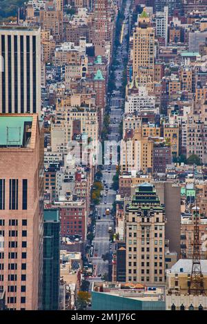 Blick von oben auf die lange New York City Street, gesäumt mit kleinen Wolkenkratzern in sanftem Licht Stockfoto