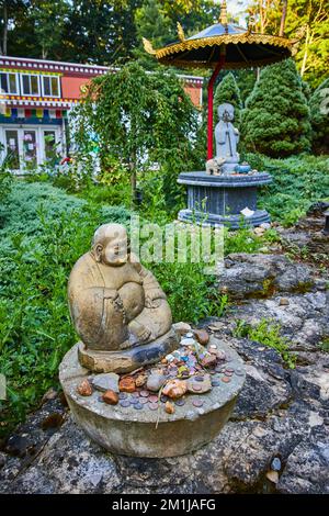 Felsen gespendet an eine Statue für den tibetischen mongolischen Buddhisten im Zen Meditationsgarten Stockfoto