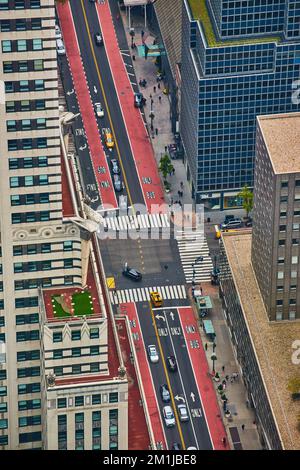 Mit Blick auf die Kreuzung von New York City mit roten und schwarzen Gassen und mit Wolkenkratzern gesäumt Stockfoto