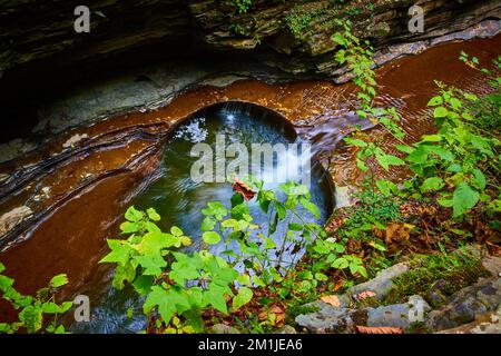 Blick auf den Fluss und den kleinen Wasserfall, der Kreise in Felsen der Schlucht schneidet Stockfoto