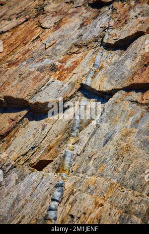 Detail einer winzigen Quarzvene, die durch Felsen in Maine verläuft Stockfoto