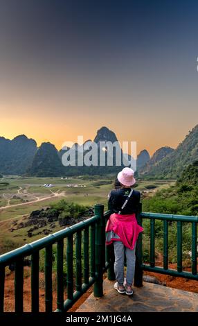 Quoc Toan-Gemeinde, Tra Linh, Cao Bang, Vietnam - 12. November 2022: Eine Touristenfrau schaut auf den einzigartigen Berg Gottes Augen bei Sonnenuntergang in Quoc Toan Stockfoto