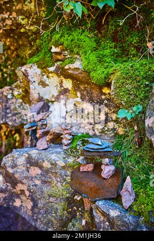 Wunderschöne Sammlung von kleinen Steinstapeln in Moss- und Flechten-bedeckten Felsen Stockfoto