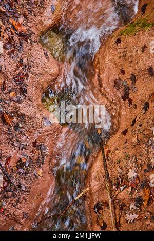 Der Fluss ist in Ton geschnitzte Wellenmuster mit Herbstblättern von oben Stockfoto