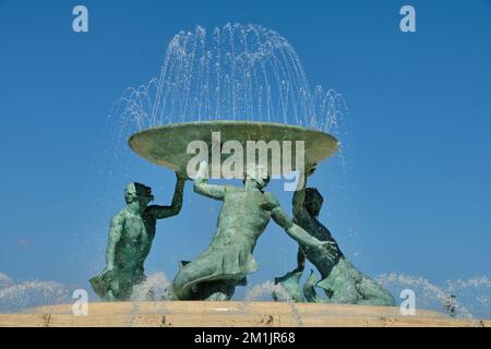Der Tritonbrunnen besteht aus drei Bronzefiguren mythologischer Tritons, die eine Platte hochhalten - Valetta, Malta Stockfoto