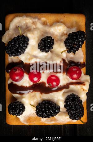 Wunderschöner süßer Dessertkuchen mit Sommerbeeren. Quadratischer Kuchen für einen Buffettisch. Stockfoto