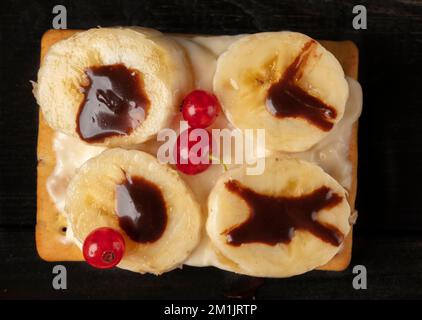 Wunderschöner süßer Dessertkuchen mit Sommerbeeren und Banane. Quadratischer Kuchen für einen Buffettisch. Stockfoto
