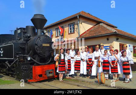 Ein Folk-Kostüm aus dem rumänischen Bezirk Maramures und die Dampfeisenbahn Mocanita aus Viseu de Sus Stockfoto