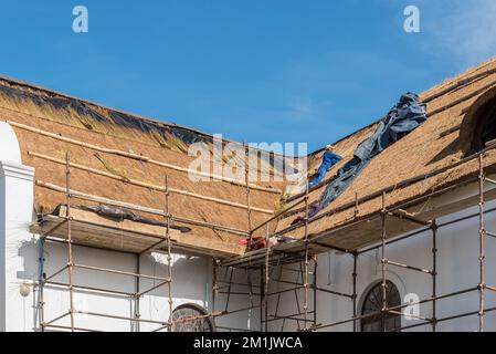 Elim, Südafrika - 21. Sept. 2022: Erneuerung des Dachs der historischen mährischen Kirche in Elim im Gange. Ein Mitarbeiter ist sichtbar Stockfoto