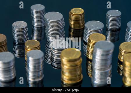 Stapel von Münzen (Polish Zloty, Grosze, PLN) auf einer schwarzen, reflektierenden Oberfläche. Inflation verschlingt unsere Ersparnisse. Schwierige Wirtschaftslage in Polen. Stockfoto