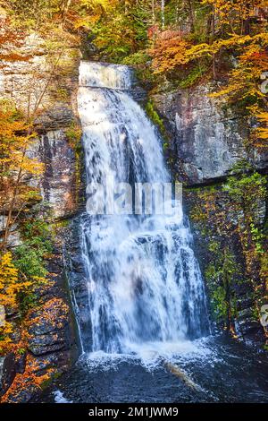 Direkt auf einem riesigen Wasserfall über Klippen mit rauem Licht und Herbstlaub Stockfoto