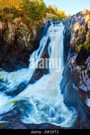 Panoramablick aus nächster Nähe auf den riesigen Wasserfall, der im Herbst durch die tiefe Schlucht aus Stein strömt Stockfoto