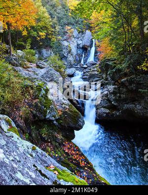 Herbstlaub umgibt Wasserfälle durch die Schlucht im atemberaubenden Herbstwald von New York Stockfoto