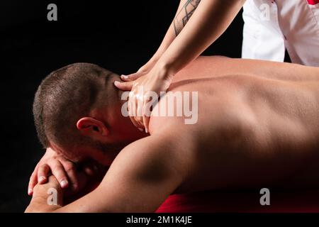 Sportmassage. Physiotherapeut-Massagemensch mit muskulärer Schulter. Sportbehandlung. Therapeut mit männlichen Schultern. Stockfoto