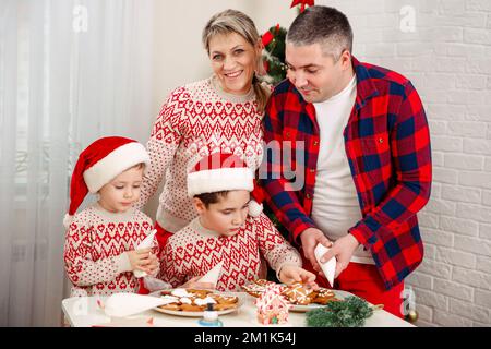 Die Familie kocht Weihnachtskekse. Kinder kochen Weihnachtskekse. Stockfoto