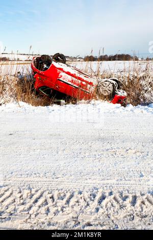 Winterfahrten in Großbritannien Ein umgestürztes Auto auf einer schneebedeckten Landstraße in Derbyshire, Emgland, Großbritannien Stockfoto