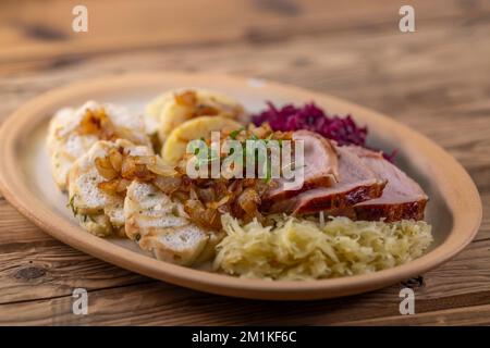 Geräuchertes Fleisch, serviert mit Rot- und Weißkohl und zwei Sorten Knödel Stockfoto