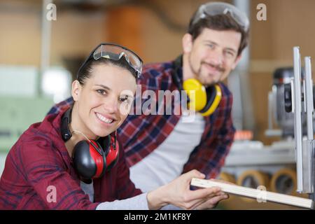 Mann erklärt Frau Holzbearbeitung Tipps in Holz workshop Stockfoto