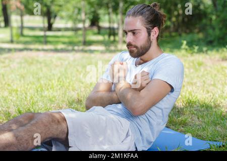 Mann tun, Sit-ups im Wald Stockfoto