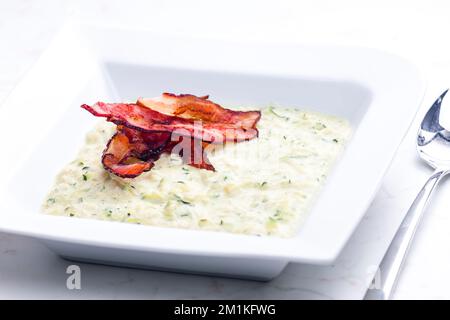 Zucchini-Suppe mit Speckstreifen Stockfoto