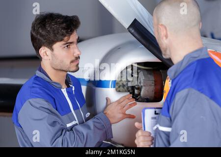 Männer überprüfen den Heck des Hubschraubers vor dem Flug Stockfoto