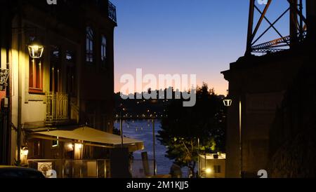 Ein wunderschöner Blick auf traditionelle Gebäude in der Nähe eines Flusses in Porto, Portugal während der Nacht Stockfoto