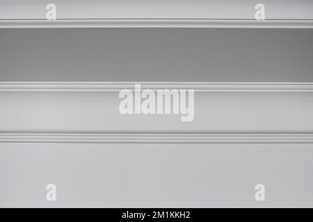 Detaildarstellung einer flachen Deckenverkleidung, weiße Deckenleisten im Innenraum Stockfoto