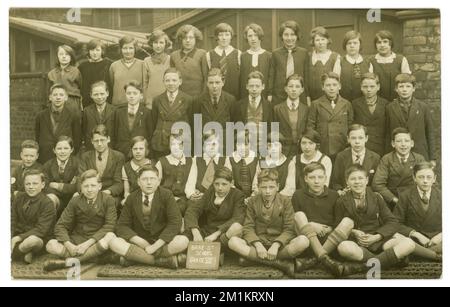 Originale Postkarte aus den 1920er Jahren, auf der die Brae Street School in der V111. Klasse gezeichnet wurde, draußen auf dem Schulspielplatz, in gemischten Schuluniformen und anderen Moden. Datiert 1927 auf der Rückseite. Liverpool, Merseyside, England, Großbritannien Stockfoto