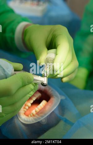 Nahaufnahme von operativ tätigen aufmerksamen Ärzten bei der Installation von Zahnimplantaten in den Mund des Patienten in einer modernen Zahnklinik. Stockfoto