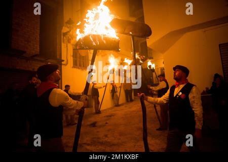 Malaga, Spanien, 12/12/2022, Dorfbewohner werden gesehen, wie sie Fackeln auf der Straße halten, während sie an der Feier der Jungfrauenprozession „Divina Pastora“ teilnehmen. Am Vorabend des Festes von St. Lucia im kleinen Dorf Casarabonela nehmen jeden Abend am 12. Dezember während der Weihnachtszeit an der antiken Feier der „Los rondeles“ Teil und tragen brennende Korbkörbe (auch bekannt als „Rondeles“) in Öl getränkt. Entlang der Straßen wird die Jungfrau von „Los rondeles“ von den Gläubigen in einem Ritual aus Licht und Feuer als Dankeschön für die Ernte geehrt. Stockfoto