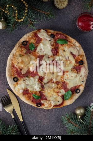 Hausgemachte Salami-Würstchen-Pizza mit Käsemöglichkeiten, Neujahrspizza-Idee für Kinderparty Stockfoto