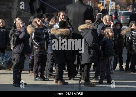 Eine Gruppe orthodoxer jüdischer Schüler beobachtet den Himmel während der Schulferien. In Brooklyn, New York. Stockfoto