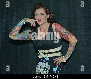 Posiertes Porträt einer Frau mit mehreren Tattoos und einer Tattoo-Tagung im Nassau Coliseum in Long Island, New York. Stockfoto