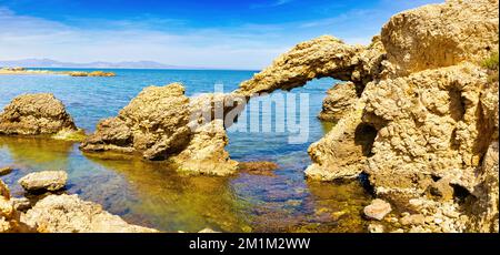 Blick auf den gelochten Felsen von Portitxol am Küstenpfad von La Escala nach Sant Martí d'Empúries, an der Costa Brava, Katalonien Spanien Stockfoto