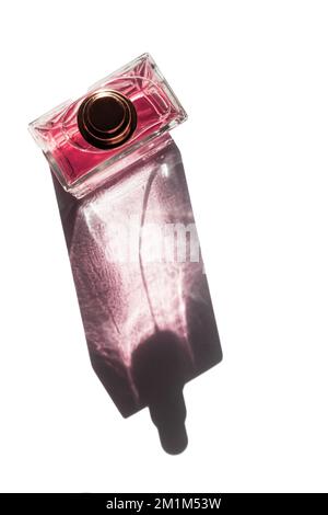 Ansicht eines einzelnen Parfümzerstäubers von oben nach unten unter hartem Magenta. Isoliert auf Weiß in minimalistischem Stil Stockfoto