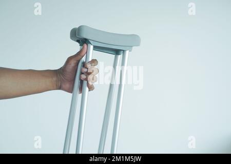 Junger Mann mit gebrochenem Bein auf Krücken. Stockfoto