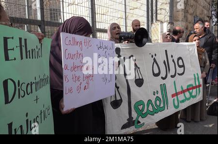 JERUSALEM, ISRAEL - DEZEMBER 13: Die Palästinenser halten Zeichen, wenn sie am Protest gegen hohe Strafen teilnehmen, die von israelischen Staatsanwälten vor dem israelischen Bezirksgericht am 13. Dezember 2022 in Ost-Jerusalem, Israel, gegen ihre Söhne gefordert wurden. Die israelischen Gerichte haben kürzlich hohe Strafen gegen arabisch-israelische Bürger wegen ihrer Beteiligung an Unruhen im Mai letzten Jahres verhängt, als die israelischen Bombardements in Gaza in mehreren arabisch-jüdischen Städten zu Gewalt und Protesten führten. Kredit: Eddie Gerald/Alamy Live News Stockfoto