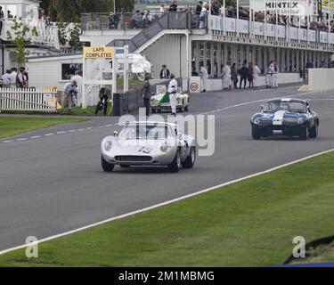 Ein Tojeiro-Ford Sportwagen aus dem Jahr 1962 führt einen Jaguar E-TYPE während der Goodwood Revival 2022 an den Gruben vorbei Stockfoto