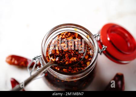Hausgemachtes asiatisches Chiliöl in einem Glasgefäß, selektiver Fokus Stockfoto