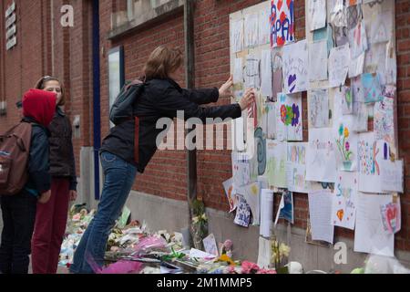 20120316 - HEVERLEE, BELGIEN: Abbildung zeigt eine Frau, die eine Zeichnung an die Wand der Grundschule (Basisschool - ecole Primaire) Sint-Lambertusschool, in Heverlee, Freitag, den 16. März 2012, klebt. Bei einem schrecklichen Busunfall am Dienstagabend in einem Tunnel, in Sierre, Valais, Schweiz, 28 Menschen, Darunter 22 Kinder, starben, 24 andere wurden verletzt. Die Kinder aus zwei Schulen von Lommel und Heverlee waren nach dem Skiurlaub auf dem Heimweg. BELGA FOTO CHRISTOPHE LEGASSE Stockfoto