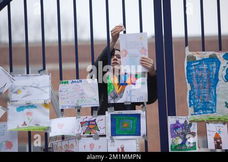 20120316 - HEVERLEE, BELGIEN: Abbildung zeigt eine Frau, die eine Zeichnung am Tor der Grundschule (Basisschool - ecole Primaire) Sint-Lambertusschool, in Heverlee, Freitag, den 16. März 2012. Bei einem schrecklichen Busunfall am Dienstagabend in einem Tunnel, in Sierre, Valais, Schweiz, 28 Menschen, Darunter 22 Kinder, starben, 24 andere wurden verletzt. Die Kinder aus zwei Schulen von Lommel und Heverlee waren nach dem Skiurlaub auf dem Heimweg. BELGA FOTO CHRISTOPHE LEGASSE Stockfoto