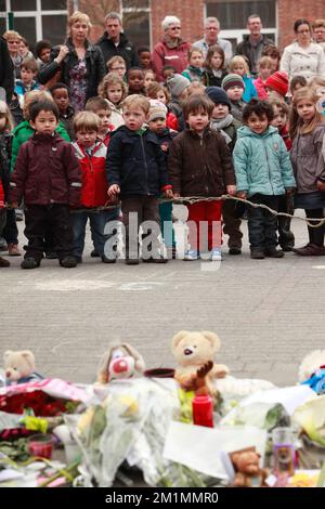 20120316 Uhr - HEVERLEE, BELGIEN: Kinder auf dem Spielplatz vor Blumen, Teddybären und Kerzen während der Schweigeminute am Tag der belgischen nationalen Trauer, rund um die Grundschule (Basisschool - ecole Primaire) Sint-Lambertusschool, in Heverlee, Freitag, 16. März 2012. Bei einem schrecklichen Busunfall am Dienstagabend in einem Tunnel, in Sierre, Valais, Schweiz, 28 Menschen, Darunter 22 Kinder, starben, 24 andere wurden verletzt. Die Kinder aus zwei Schulen von Lommel und Heverlee waren nach dem Skiurlaub auf dem Heimweg. BELGA FOTO CHRISTOPHE LEGASSE Stockfoto