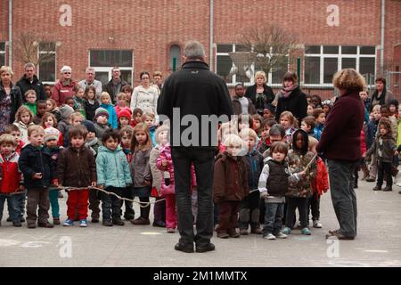 20120316 Uhr - HEVERLEE, BELGIEN: Kinder auf dem Spielplatz während der Schweigeminute am Tag der belgischen Nationaltrauer, um die Grundschule (Basisschool - ecole Primaire) Sint-Lambertusschool, in Heverlee, Freitag, 16. März 2012. Bei einem schrecklichen Busunfall am Dienstagabend in einem Tunnel, in Sierre, Valais, Schweiz, 28 Menschen, Darunter 22 Kinder, starben, 24 andere wurden verletzt. Die Kinder aus zwei Schulen von Lommel und Heverlee waren nach dem Skiurlaub auf dem Heimweg. BELGA FOTO CHRISTOPHE LEGASSE Stockfoto